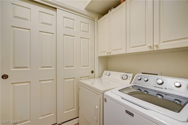 laundry room with cabinets and washing machine and clothes dryer