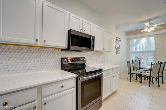 kitchen featuring light tile patterned flooring, tasteful backsplash, white cabinets, ceiling fan, and stainless steel appliances