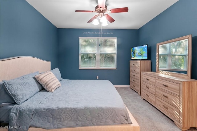 carpeted bedroom featuring multiple windows and ceiling fan