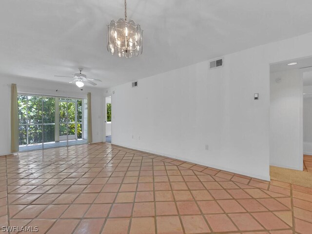 tiled empty room featuring ceiling fan with notable chandelier