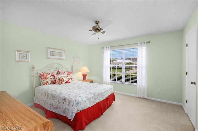 bedroom with carpet flooring, ceiling fan, and a textured ceiling