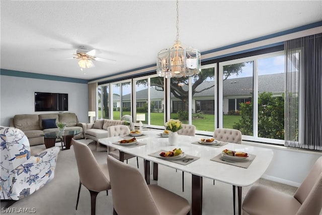 carpeted dining area with ceiling fan with notable chandelier