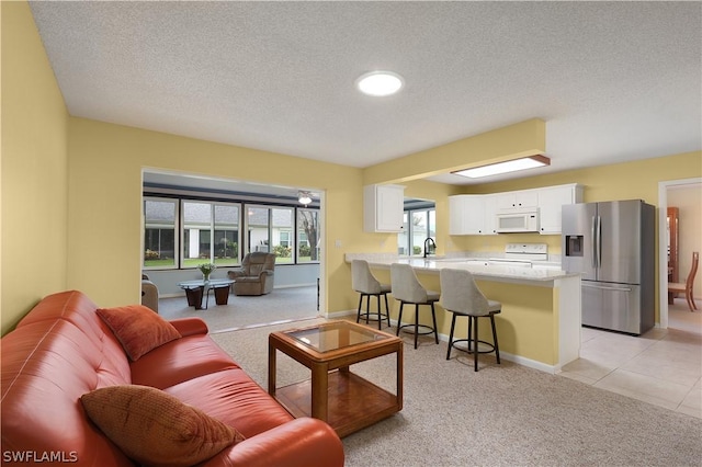 living room featuring a textured ceiling, light colored carpet, and sink