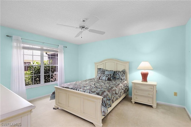 bedroom featuring a textured ceiling, ceiling fan, and light carpet