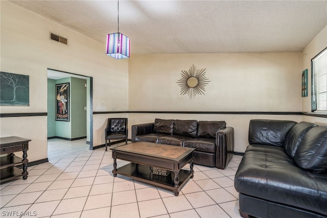 tiled living room featuring a textured ceiling