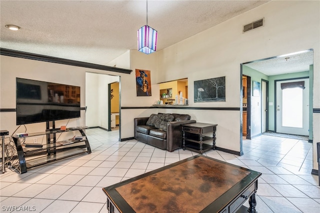 tiled living room featuring ornamental molding and a textured ceiling