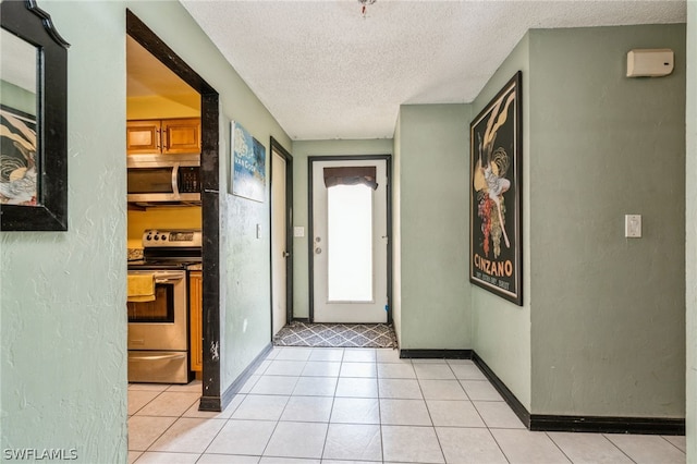 foyer with a textured ceiling and light tile patterned floors