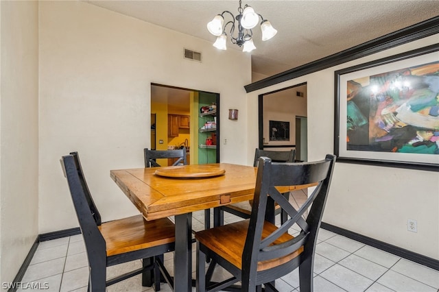 dining room with a notable chandelier, a textured ceiling, and light tile patterned flooring