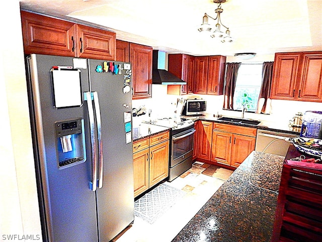 kitchen with appliances with stainless steel finishes, dark stone countertops, wall chimney exhaust hood, and a chandelier