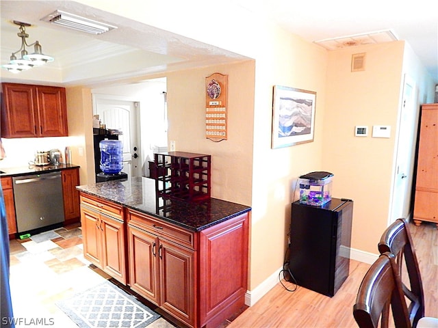 kitchen featuring light wood-type flooring, a tray ceiling, dishwasher, and dark stone counters