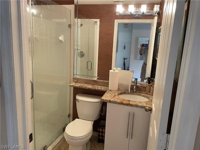 bathroom with an enclosed shower, vanity, tile patterned flooring, and toilet