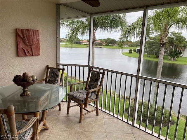 sunroom featuring a water view