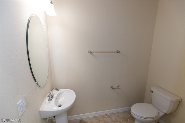 bathroom with tile patterned flooring, toilet, and sink