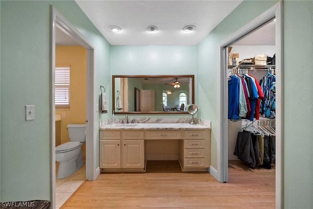 bathroom featuring ceiling fan, hardwood / wood-style flooring, vanity, and toilet