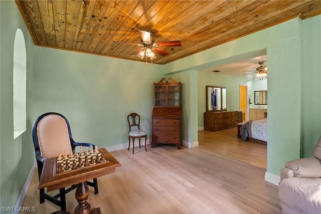 sitting room with light wood-type flooring, ceiling fan, crown molding, and wooden ceiling