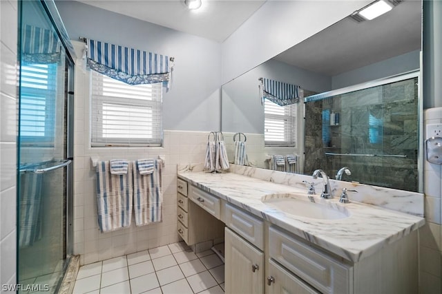 bathroom featuring plenty of natural light, tile patterned floors, tile walls, and vanity