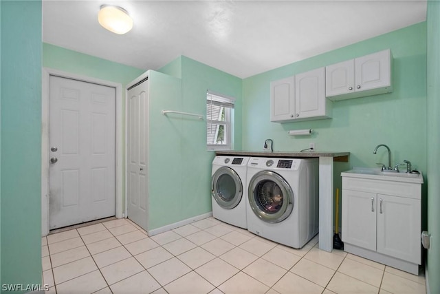 laundry room featuring sink, washer and clothes dryer, and cabinets