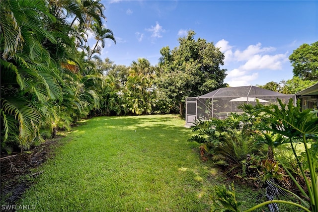 view of yard with glass enclosure