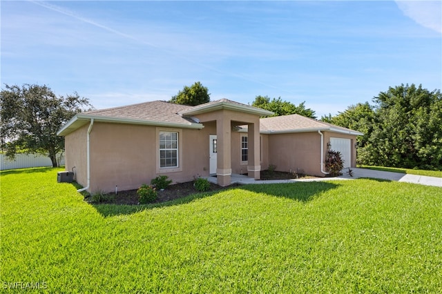 view of front of property featuring a garage, a front lawn, and central air condition unit