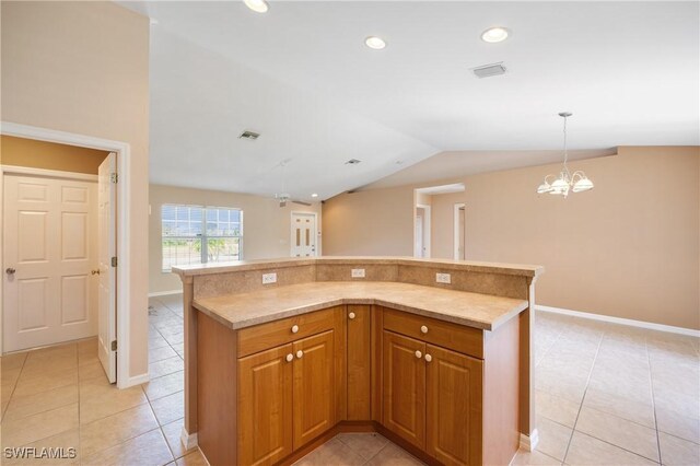 kitchen with light tile patterned floors, lofted ceiling, pendant lighting, and a chandelier