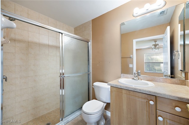 bathroom featuring vanity, walk in shower, tile patterned flooring, ceiling fan, and toilet