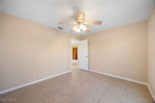 tiled empty room featuring ceiling fan