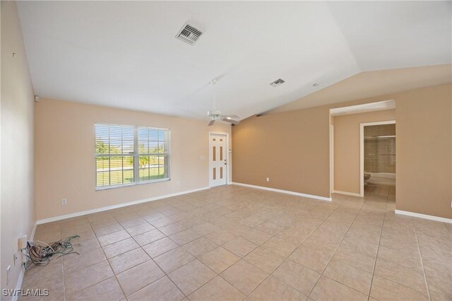 spare room featuring ceiling fan, light tile patterned flooring, and lofted ceiling