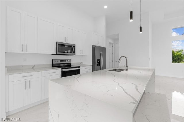 kitchen with white cabinetry, sink, stainless steel appliances, and decorative light fixtures