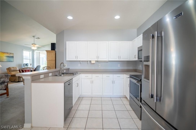 kitchen with sink, ceiling fan, stainless steel appliances, white cabinets, and kitchen peninsula