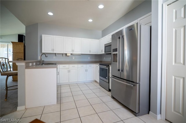 kitchen featuring white cabinets, a kitchen bar, stainless steel appliances, and sink