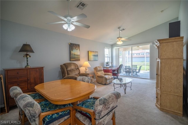 dining room with ceiling fan, light colored carpet, and vaulted ceiling