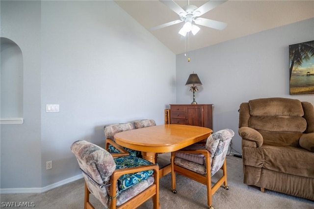 dining space featuring light colored carpet, ceiling fan, and lofted ceiling