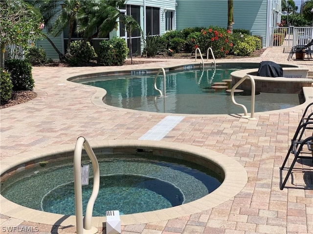 view of pool featuring a hot tub and a patio area