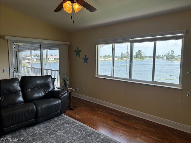 living room with dark hardwood / wood-style floors, vaulted ceiling, a wealth of natural light, and ceiling fan