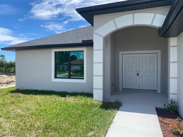 view of exterior entry with a yard