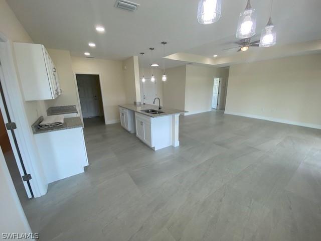 kitchen featuring white cabinetry, ceiling fan, decorative light fixtures, and sink