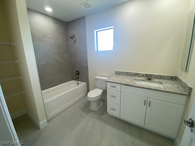 full bathroom featuring vanity, toilet, and tiled shower / bath combo