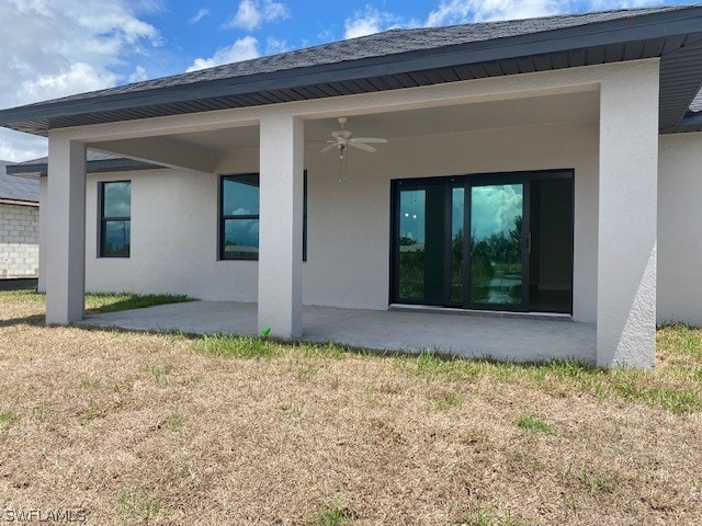 rear view of property featuring a yard, ceiling fan, and a patio area