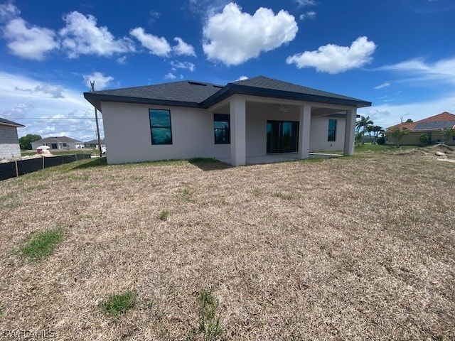 rear view of house featuring a yard