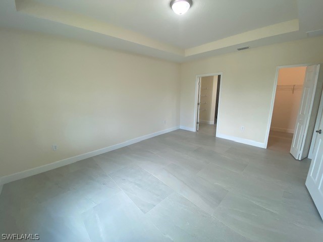 unfurnished room featuring a tray ceiling