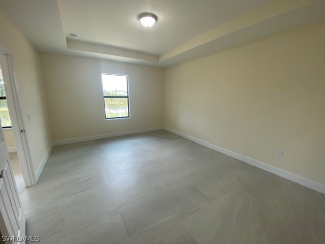 spare room with a raised ceiling