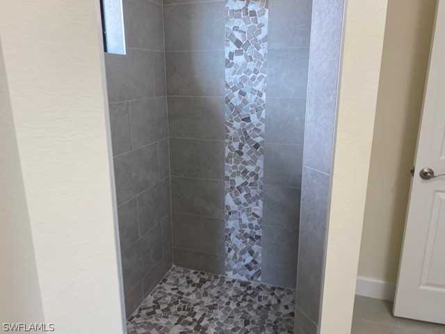 bathroom featuring a tile shower and tile patterned floors