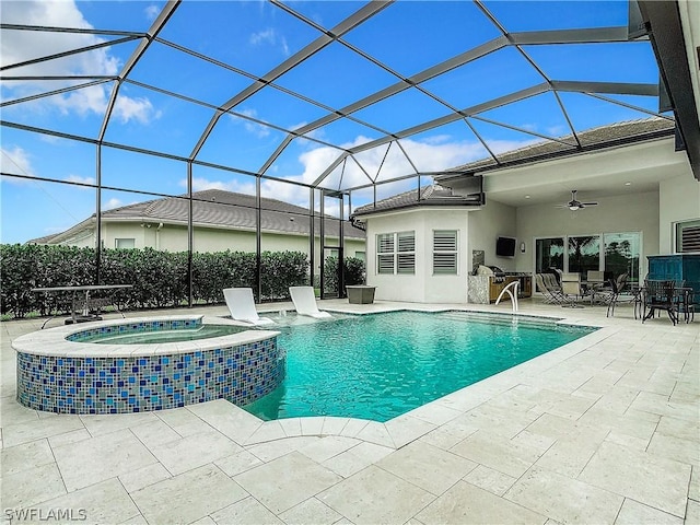 view of pool featuring glass enclosure, ceiling fan, a patio area, and an in ground hot tub