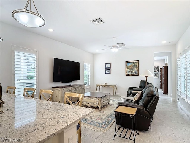 living room featuring a wealth of natural light, ceiling fan, and light tile patterned floors