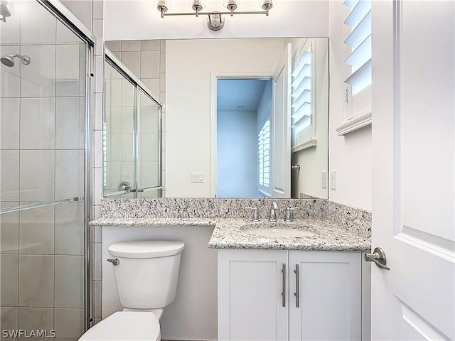 bathroom with vanity, toilet, and walk in shower