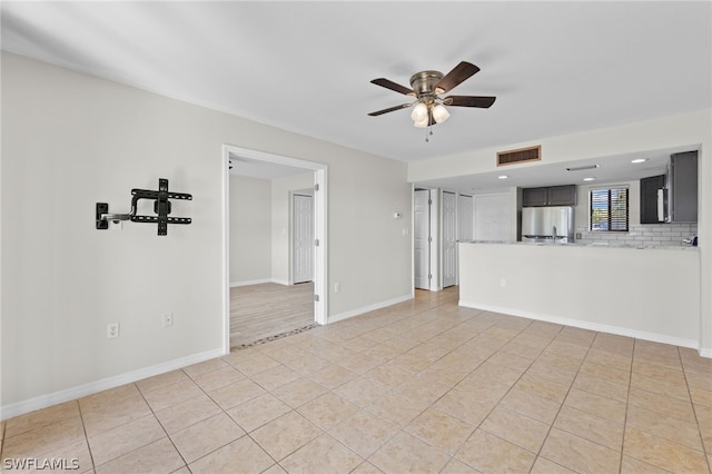 unfurnished living room with ceiling fan and light tile patterned floors