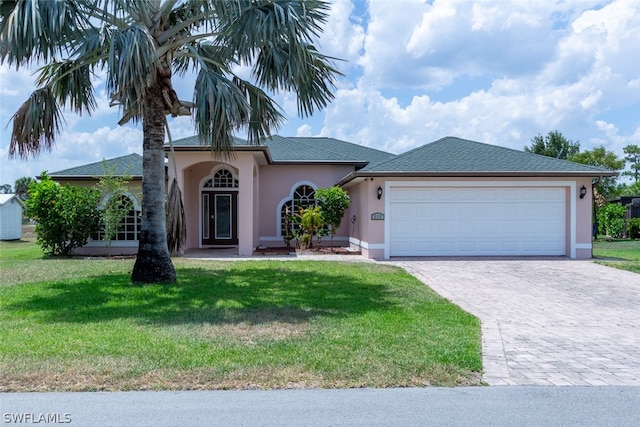 view of front of property with a front yard and a garage