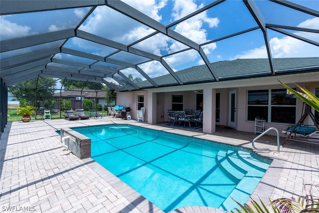 view of swimming pool featuring a patio and glass enclosure