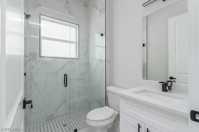 bathroom featuring vanity, toilet, and a shower with shower door