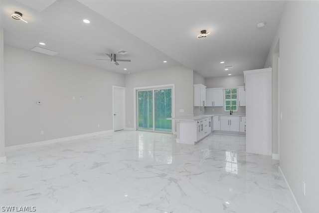 unfurnished living room with ceiling fan and sink